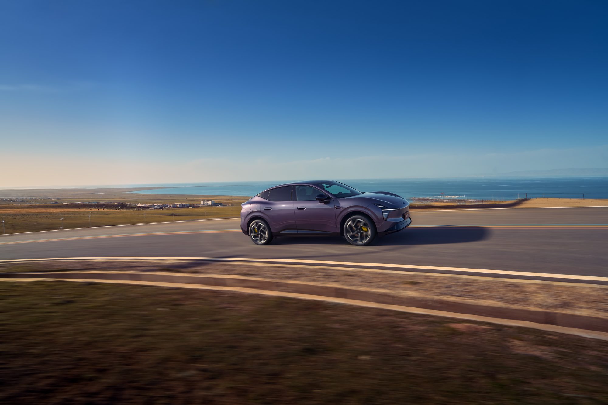 The XPENG L03 REEV in purple driving on a coastal road